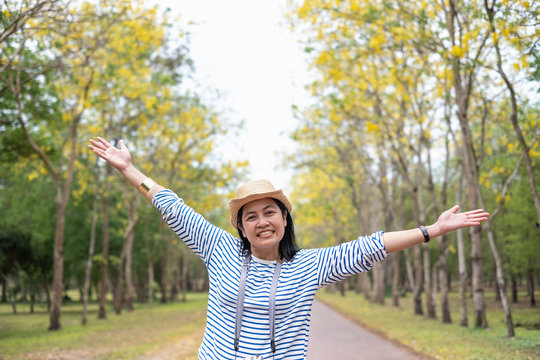 Asian traveler woman backpacker raise arm up  look at camera and smile with enjoy moment at forest in autumn season,Freedom wanderlust travel.solo backpack.