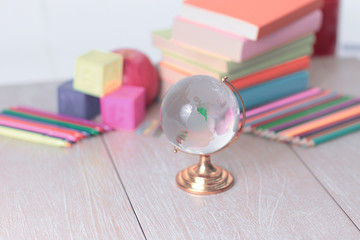 glass globe and school supplies on wooden background.photo with 