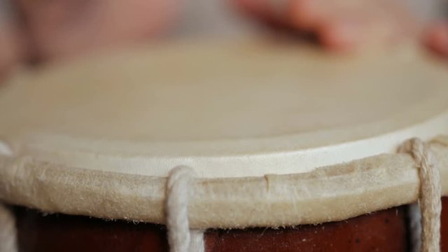 Close up of hands of a man playing a drum.