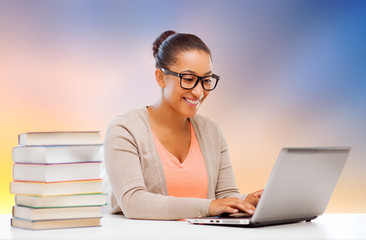 education, school and technology concept - smiling african student girl with laptop and books