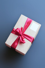Top View of Gift Box with Ribbon and Empty Stamp on Blue Background