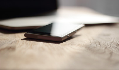 close up. blurred image of a mobile phone and laptop on the desk