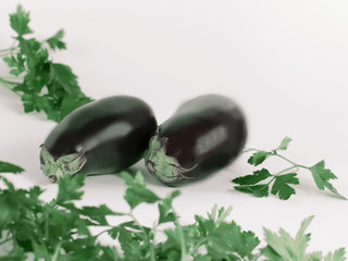 closeup.eggplants and sprigs of parsley isolated on white backgr