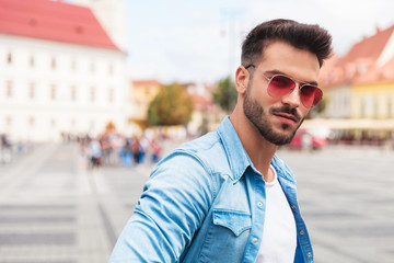 portrait of casual man with sunglasses outside in the city