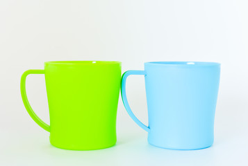 blue and green plastic mug isolated on white background. selective focus.