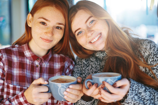 Smiling beautiful young women posing with coffee