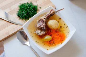 Shurpa is a traditional soup of Central Asian cuisine. Traditional Uzbek or Tatar soup with large sliced vegetables and lamb meat, clear broth, served hot with chopped dill and parsley