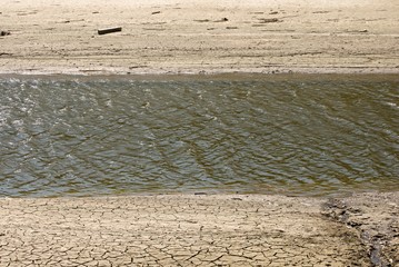 A trough of drying rivers surrounded by dry, cracked mud