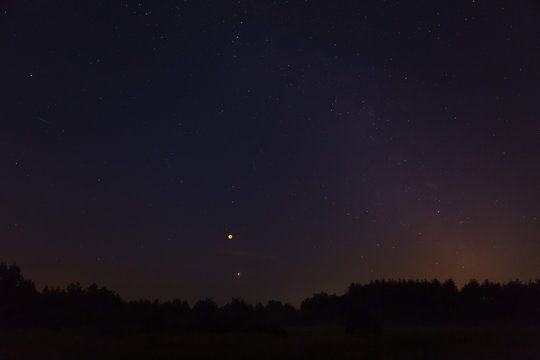 Night sky over forest, visible full eclispse of Moon, Mars in perigee and Milky Way
