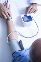 doctor measuring the blood pressure of a senior