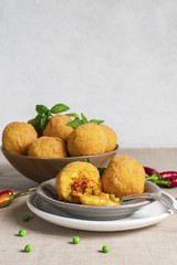 Arancini - italian rice balls which are coated with bread crumbs and then deep fried, filled with ragù (meat and tomato sauce) and peas.