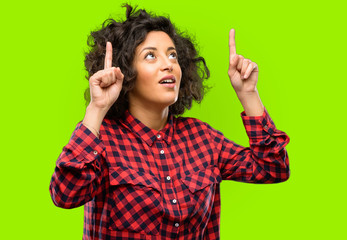 Beautiful arab woman happy and surprised cheering expressing wow gesture pointing up