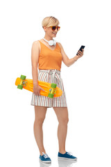 sport, leisure and skateboarding concept - smiling teenage girl in sunglasses with short modern cruiser skateboard and smartphone over white background