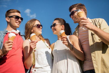 friendship, leisure and people concept - group of smiling friends with ice cream outdoors in summer