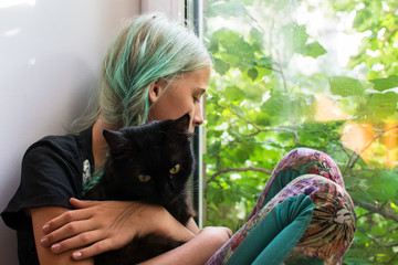 girl teenager on the window with a black cat