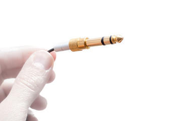Hand with stereo audio cable gold coated adapter isolated on white background