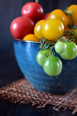 Close-up of cherry tomatoes of three colours in a blue bowl