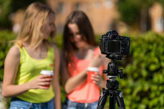 Two girlfriends girl bloggers. Summer in nature. Writes the video to the camera. Free space for text. Blurred background.