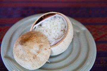 Jasmine rice in young coconut shell. Beautiful and rustic concept style of Food Styling, creative plating and decorating presentation idea, arrangement for party and fine-dining restaurant.