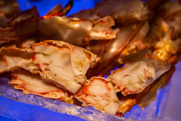 Fresh, juicy and tasty poached Alaskan king crab or Taraba crab chopped in their shell on ice bed. One of the sweetest, most flavorful crab on Earth.