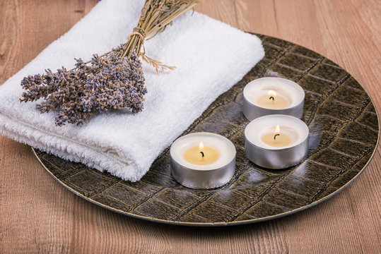 Spa decoration with candles, towels and dry lavender
