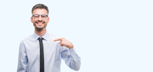 Young business man with surprise face pointing finger to himself