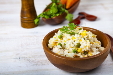 Boiled rice with vegetables in a wooden bowl