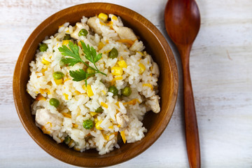 Boiled rice with vegetables in a wooden bowl