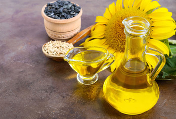 Golden organic oil in a small glass jug, sunflower, sunflower seeds. Agriculture, oil production. Bio and organic concept of the product.