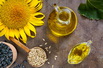 Golden organic oil in a small glass jug, sunflower, sunflower seeds. Agriculture, oil production. Bio and organic concept of the product. - Powered by Adobe