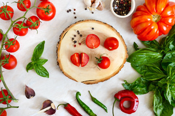 Cherry tomato branch, garlic, fresh basil, pepper on a light background. Ingredients for making sauces. Italian Cuisine.