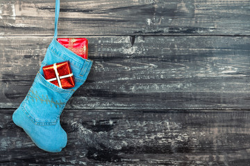 Blue christmas boot with gifts on wooden background
