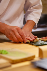 Professional and experienced sushi chef is focus and carefully make sushi with confident and dedication to perfection. Precision and Finesse at its best practice to achieve top performance in business