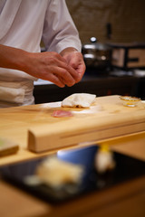 Professional sushi chef carefully using just the right pressure to make perfect sushi with...