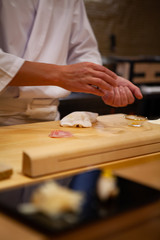 Obraz na płótnie Canvas Professional sushi chef carefully using just the right pressure to make perfect sushi with confident and dedication. Precision and Finesse at its best practice to achieve top performance in business.