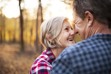 Fototapeta premium Senior couple on a walk in an autumn forest.