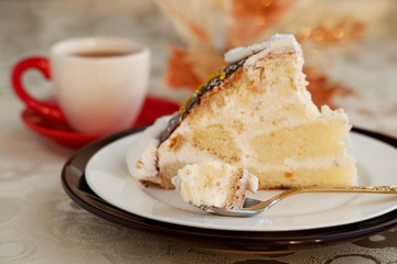 Dessert in a small spoon. A piece of cake in a dessert spoon. Cake on a silk tablecloth. Dessert in...