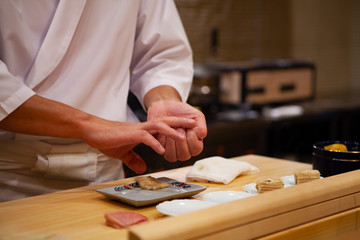 Professional sushi chef carefully using just the right pressure to make perfect sushi with...