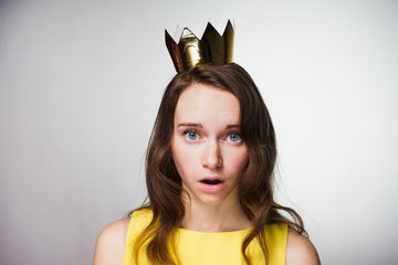 surprised blue-eyed girl in yellow dress looks at camera, looks sad