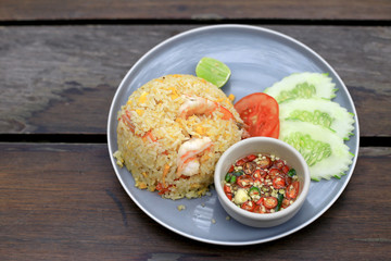 Healthly foods Fried Rice with Shrimp and some vegetables with Chilli and fish sauce in the plate on wooden table background, Thai foods traditional concept.