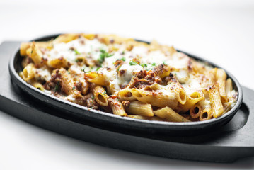 oven baked fresh pasta penne bolognese and mozzarella cheese dish