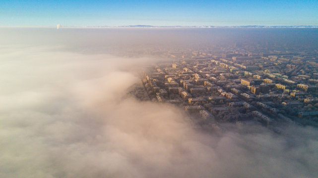 Aerial photo of city Magnitogorsk with the looming fog in the winter evening, Low lying cloud over the city