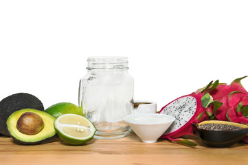 Ingridientes for energy smoothies with an empty mason jar on a w