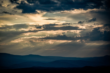 Beautiful clouds with sun penetrating them during sunset.