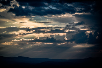 Beautiful clouds with sun penetrating them during sunset.