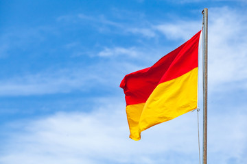 Red and yellow warning flag on a beach