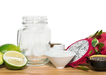 Ingridientes for energy smoothies with an empty mason jar on a w