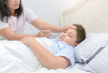 Obraz premium Mother measuring temperature of her ill kid.
