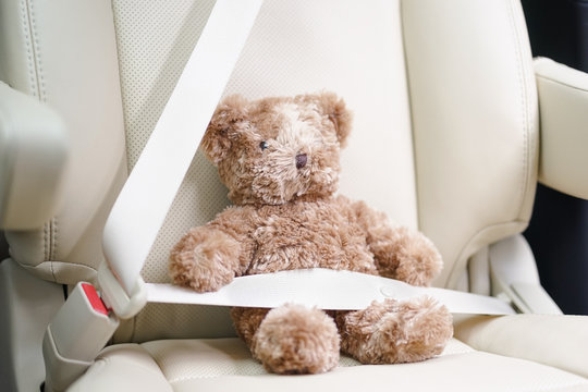 Teddy bear, fasten the seatbelt for your child safety. Child in car concept. Soft focus on the teddy bear's nose. - Powered by Adobe