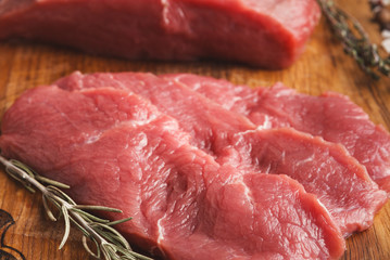 Raw beef filet mignon steaks on wooden board